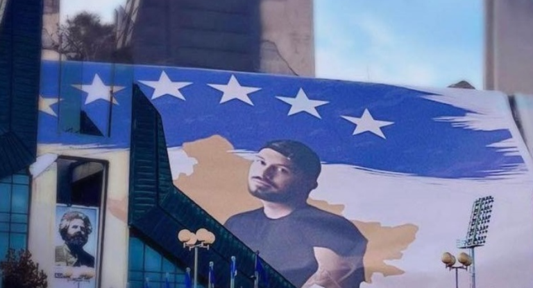 Vendosja e banerit të Donald Veshajt afër Adem Jasharit nxitë reagime të qytetarëve